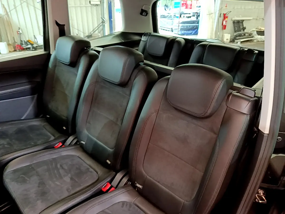 Vue intérieure montrant les sièges individuels noirs de la 2ème et 3ème rangée du Volkswagen Sharan 2017.