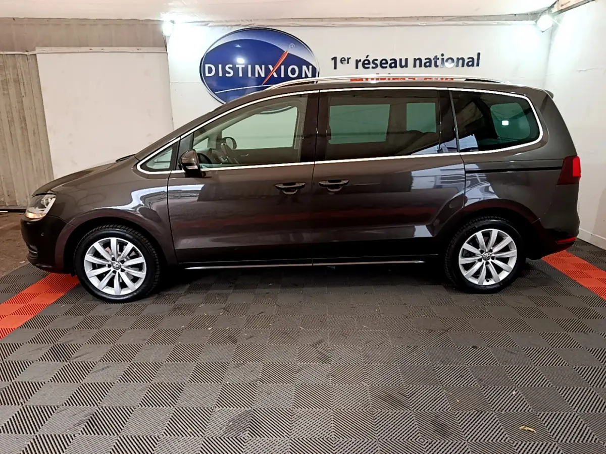 Vue latérale droite d'un Volkswagen Sharan marron 2017 garé en intérieur avec jantes alliage et vitres teintées.