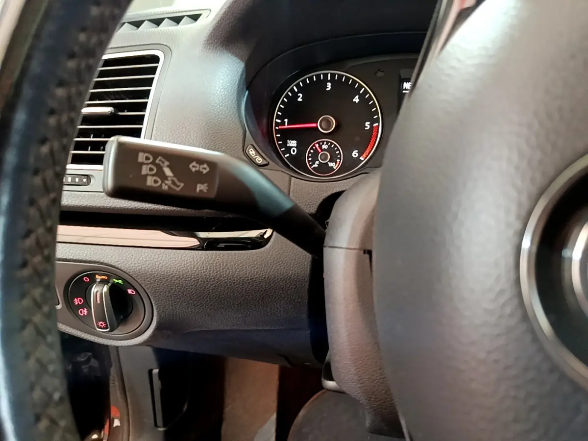 Gros plan sur le volant et le commodo gauche du tableau de bord du Volkswagen Sharan 2017, intérieur noir.