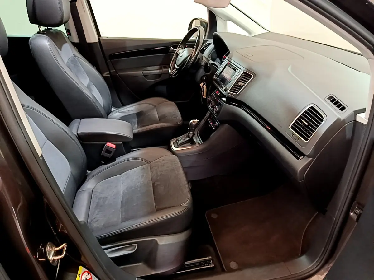 Intérieur avant du Volkswagen Sharan 2017 marron, montrant sièges cuir et alcantara, tableau de bord avec écran tactile.