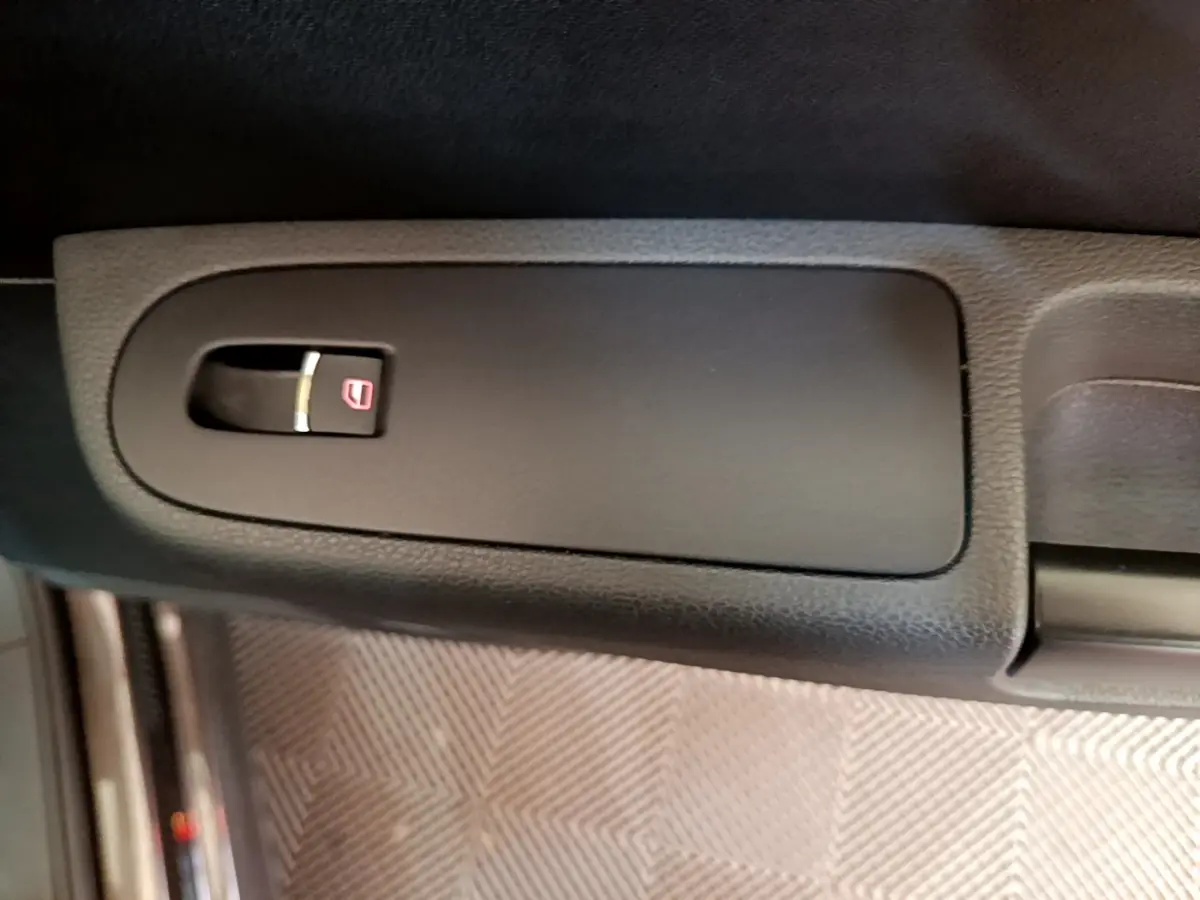 Gros plan sur le bouton de verrouillage des portes côté intérieur d'une Volkswagen Sharan 2017 marron.