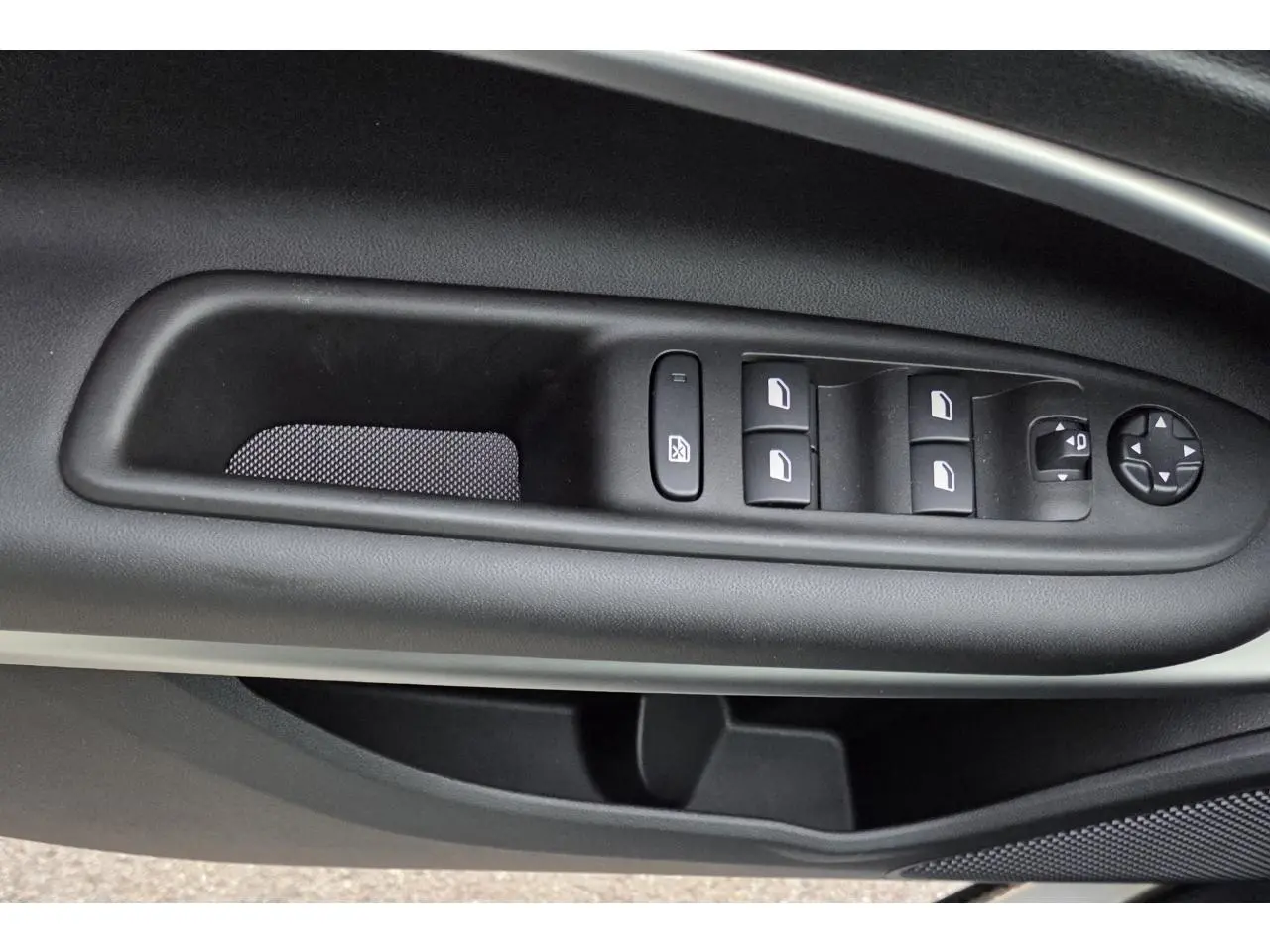 Gros plan sur les commandes de lève-vitres et rétroviseurs côté gauche intérieur du Jeep Avenger 2025 finition Summit.