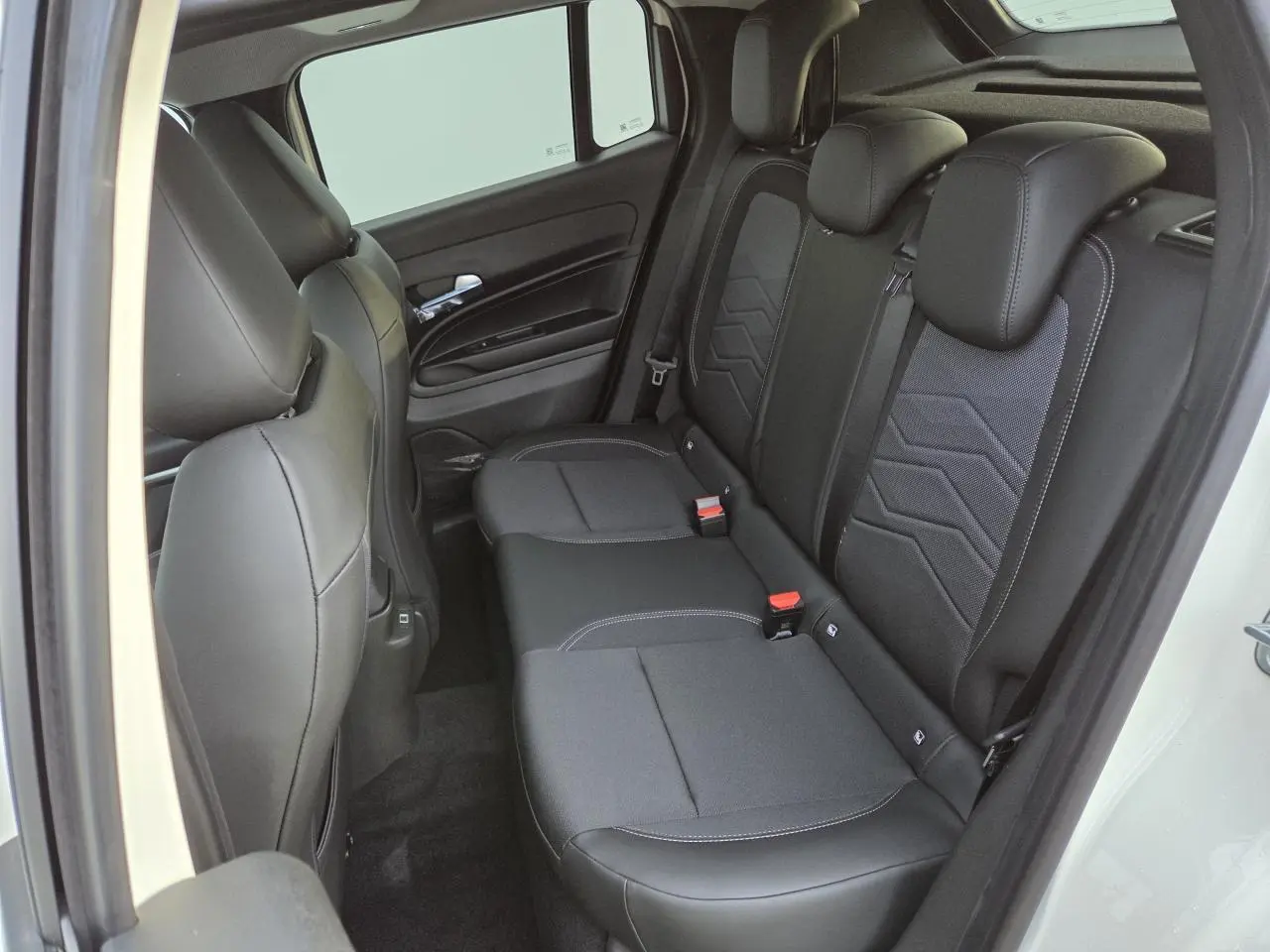 Vue côté droit sur la banquette arrière noire mixte tissu et TEP du Jeep Avenger 2025 couleur Snow avec détails gris.