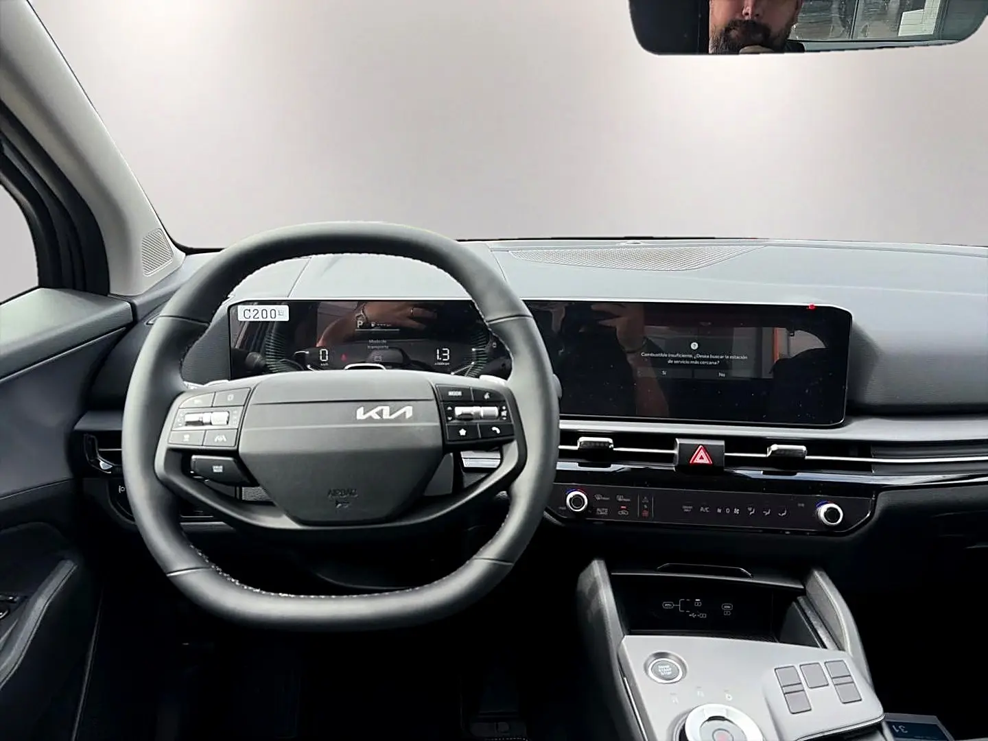 Vue intérieure frontale du tableau de bord et volant cuir noir du Kia Sportage 1.6 hybride gris eclipse 2026.
