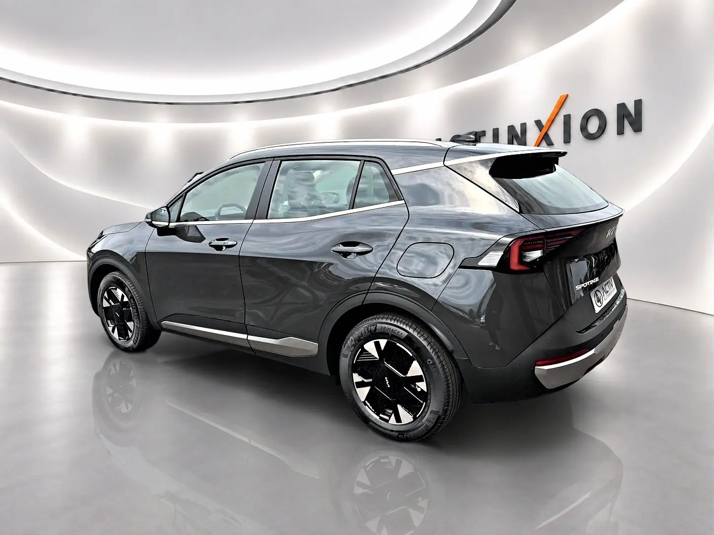 Vue 3/4 arrière droite du KIA SPORTAGE 1.6 hybride 239 gris eclipse avec jantes alu noires et feux arrière LED.