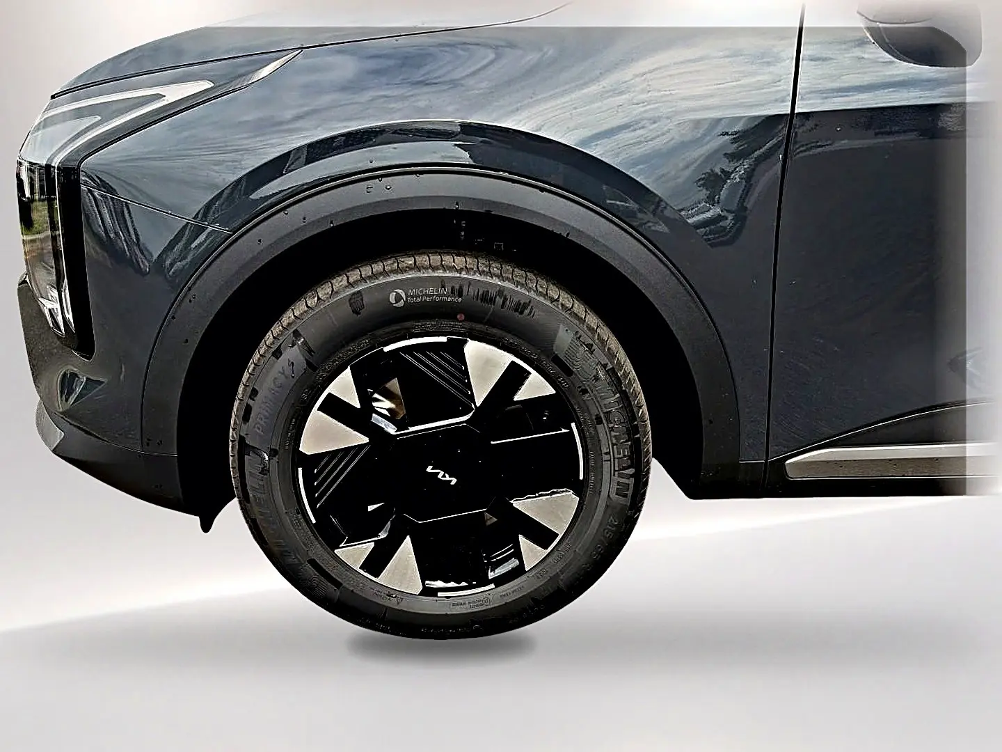 Gros plan sur la roue avant gauche du KIA SPORTAGE gris eclipse avec jante alu noire et détails modernes.
