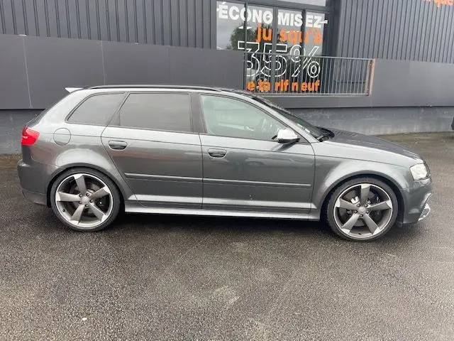 Audi RS3 Sportback gris Daytona vue de profil côté gauche, avec jantes alliage cinq branches et vitres teintées.