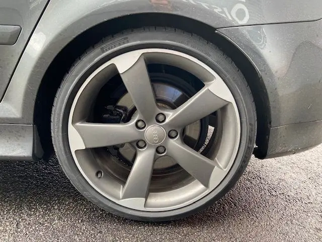 Gros plan sur la jante grise Dayton d'une Audi RS3 Sportback 2012, mettant en valeur le logo Audi au centre.