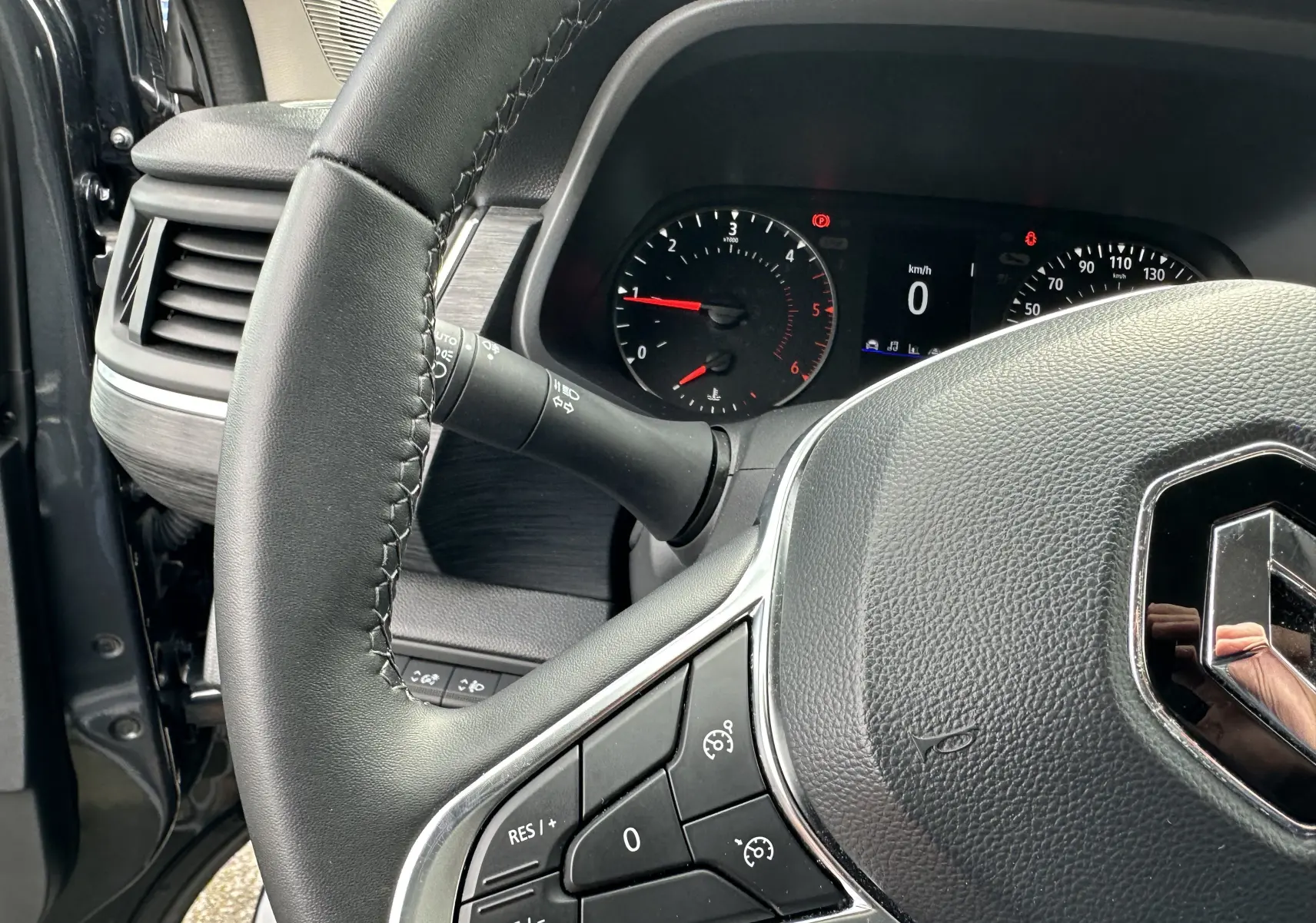 Gros plan sur le volant en cuir noir et le tableau de bord digital du Renault Trafic Combi gris Comète 2023.