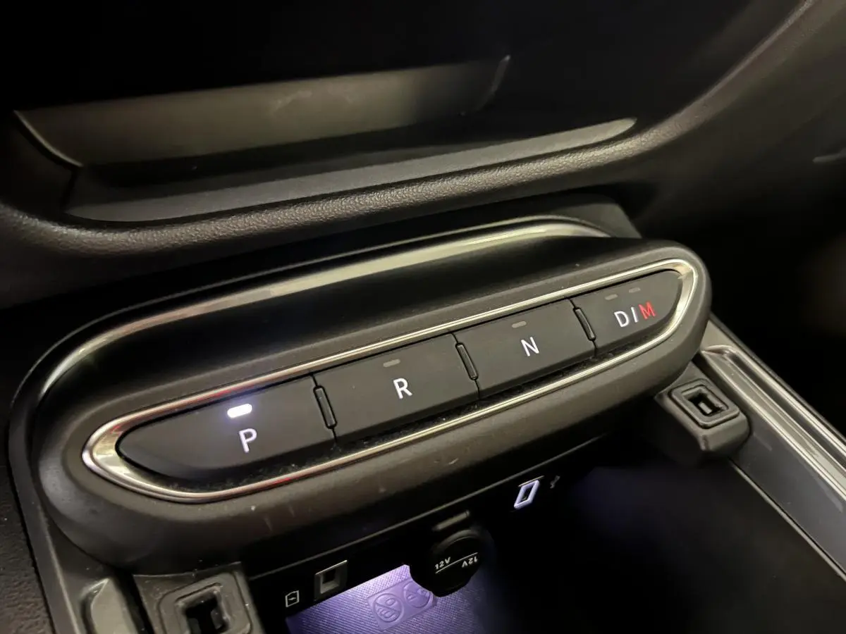 Gros plan sur la console centrale de la FIAT 600 blanche 2024, montrant les boutons de la boîte auto et prise 12V.