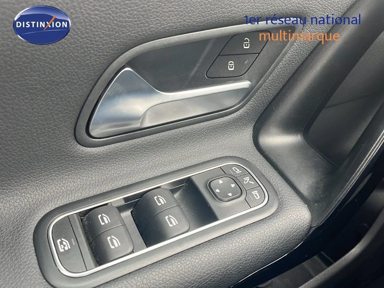 Gros plan sur la commande des vitres et la poignée intérieure côté conducteur d'une Mercedes CLA Shooting Brake argent iridium.