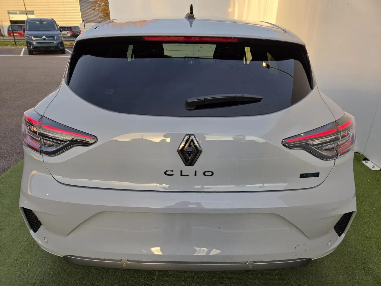 Vue arrière d'une Renault Clio gris Rafale avec feux LED et logo Renault au centre du hayon.