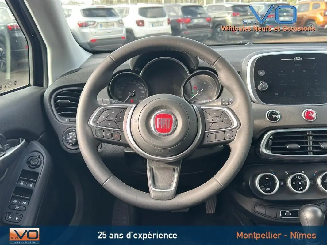 Vue centrée sur le volant et tableau de bord du Fiat 500X noir MY23 avec commandes au volant et écran tactile.