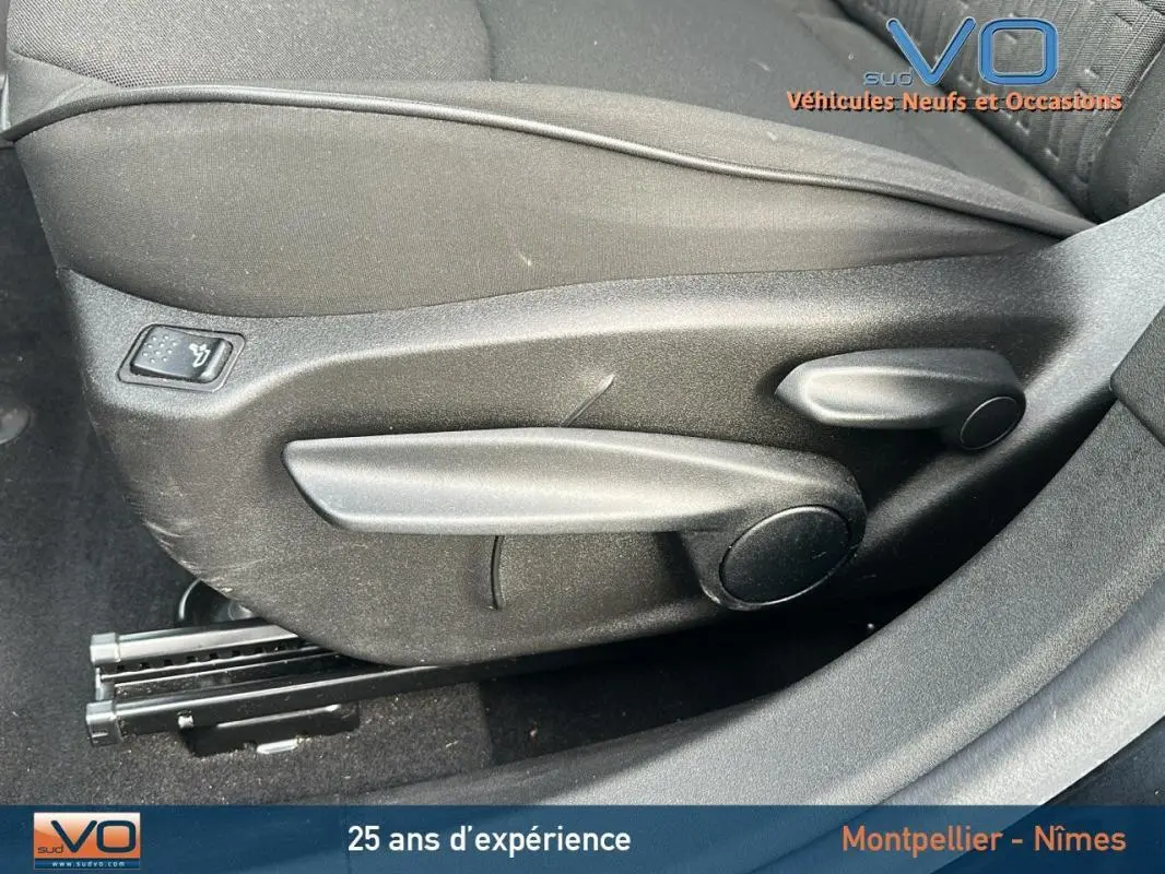 Détail des commandes de réglage manuel du siège avant côté gauche du FIAT 500X noir MY23 hybride.