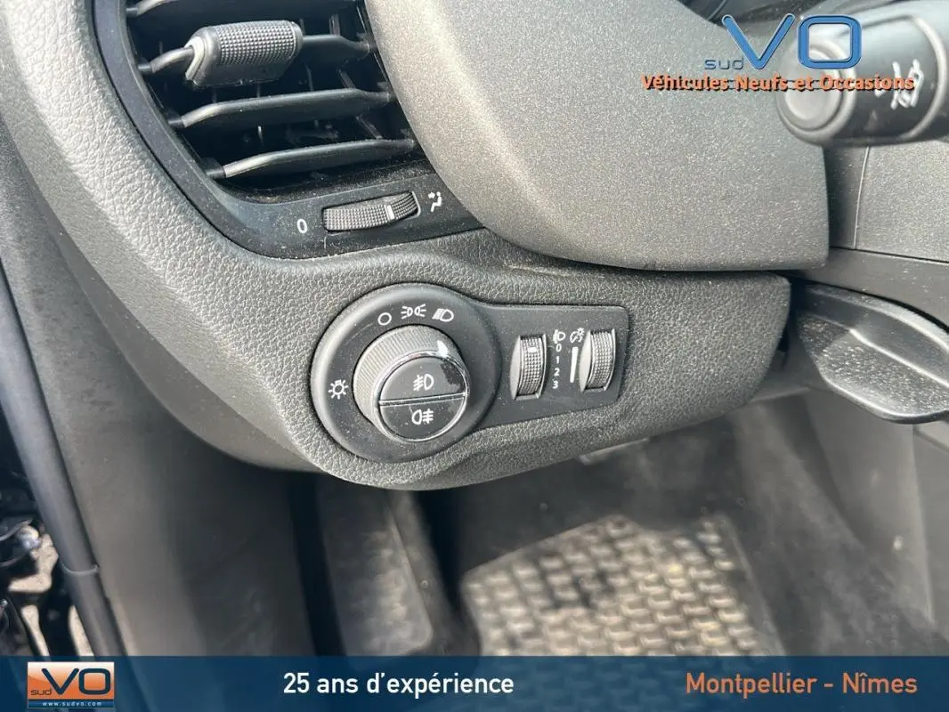 Gros plan sur le tableau de bord noir du Fiat 500X MY23, avec commandes des phares et ventilation visibles.