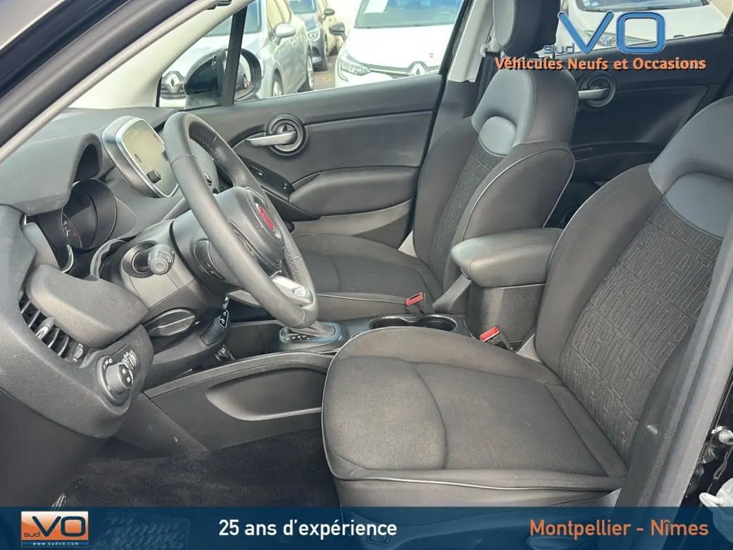 Intérieur noir du Fiat 500X MY23, vue côté conducteur montrant sièges et tableau de bord moderne.