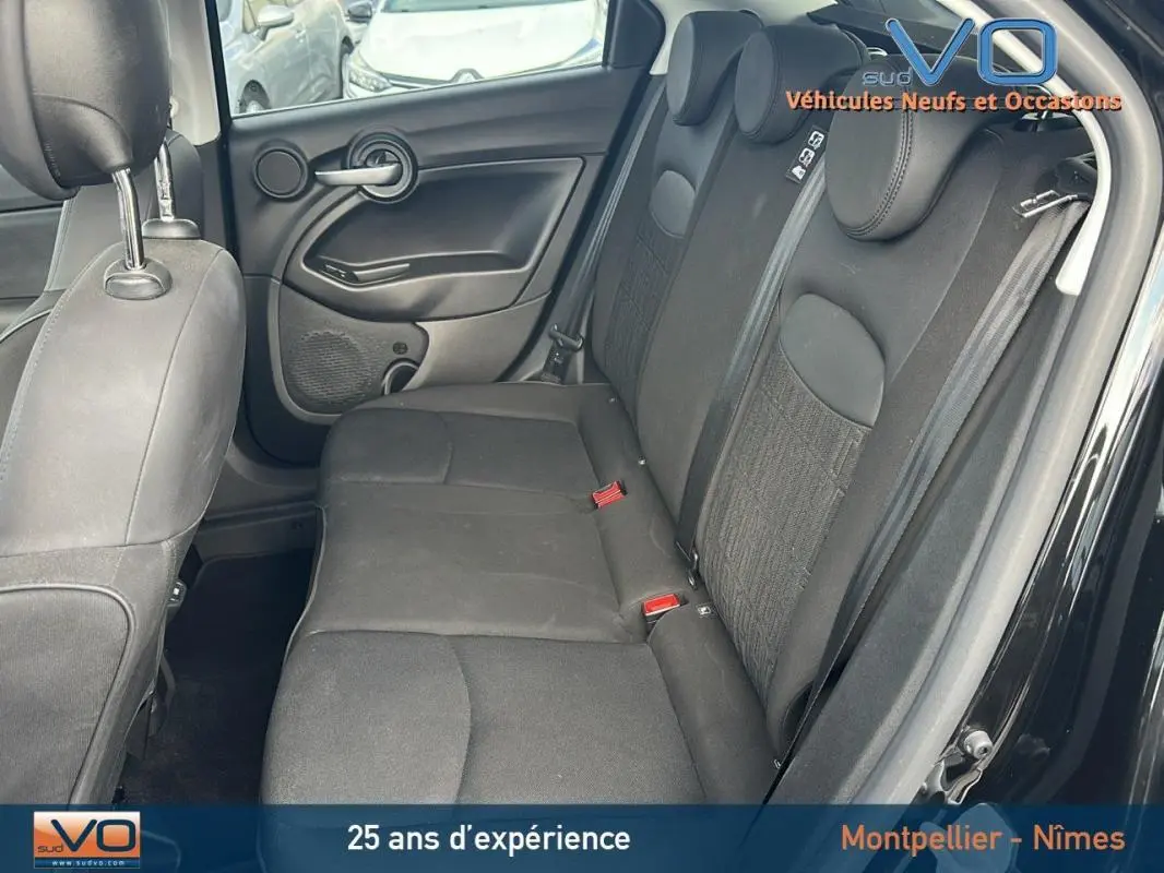 Vue intérieure côté droit des sièges arrière noirs du Fiat 500X MY23 avec ceintures et appuie-têtes visibles.