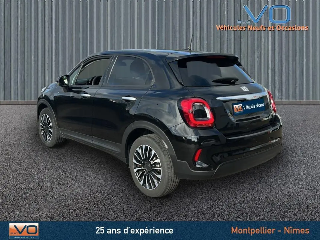 Vue 3/4 arrière droite d'une FIAT 500X noire 2023 avec jantes classiques 16 pouces et feux arrière distinctifs.