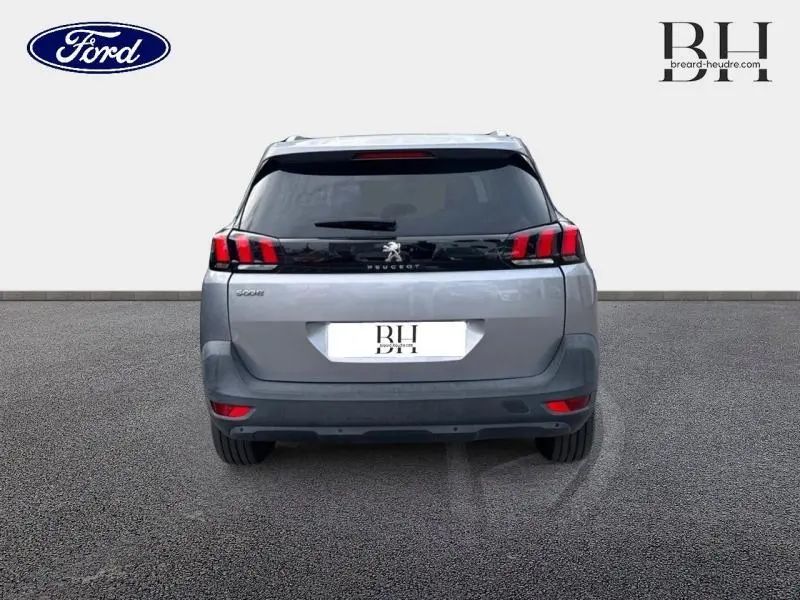 Vue arrière d'un Peugeot 5008 gris Artense avec feux arrière LED caractéristiques et lunette arrière teintée.