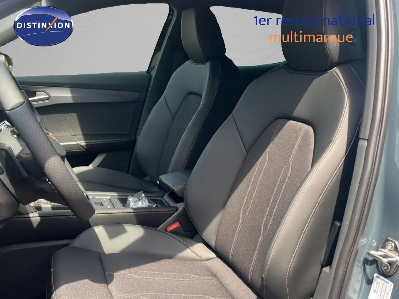 Vue intérieure côté conducteur du CUPRA Formentor 1.5 eTSI 2026 avec sièges en tissu et cuir noir, détails de la console centrale visibles.