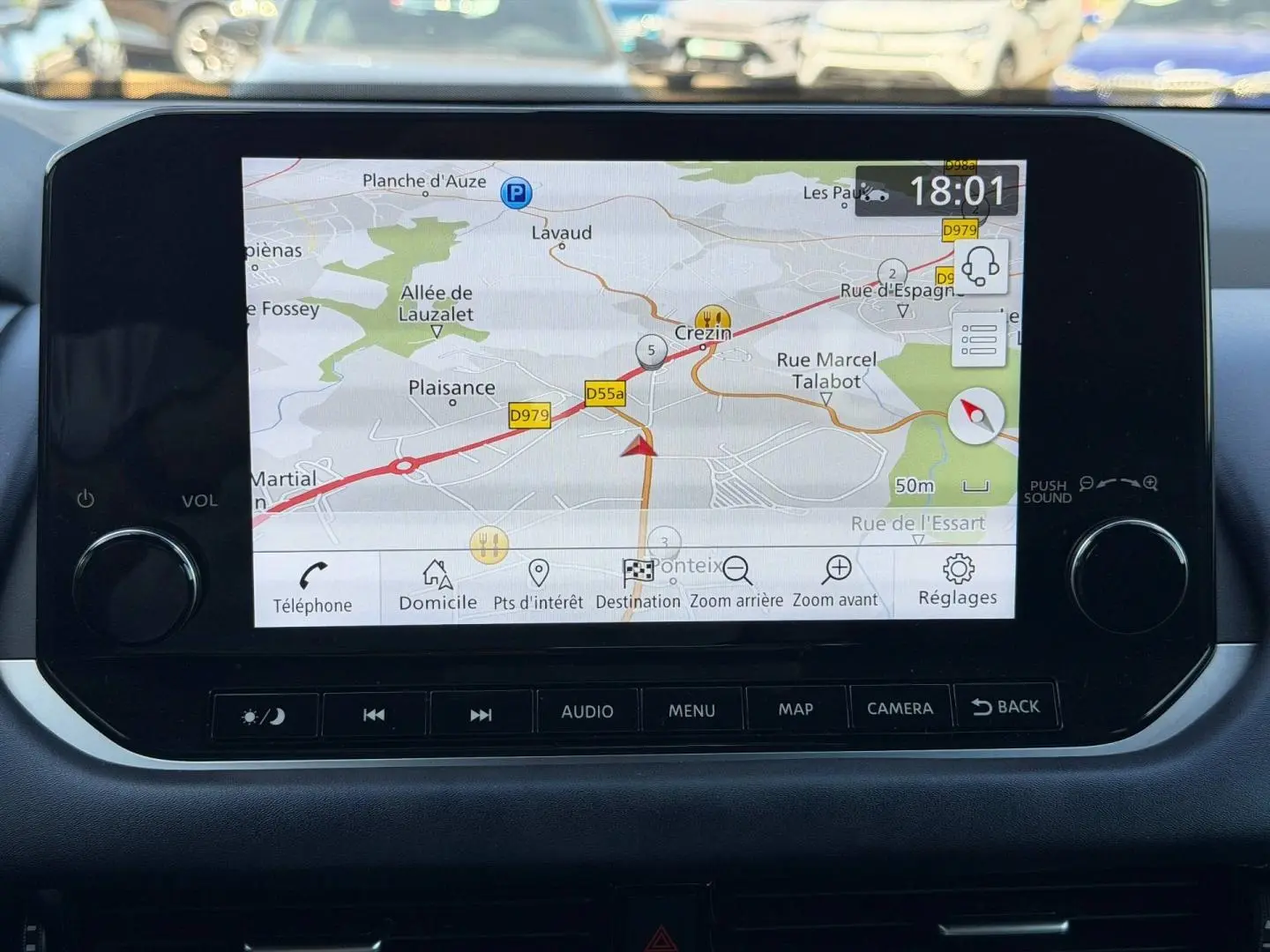 Écran tactile central du Nissan Qashqai 2022 affichant la navigation GPS avec commandes audio et menu en dessous.