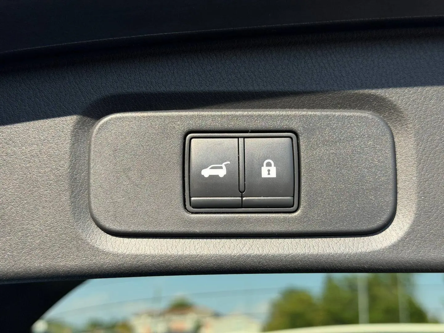 Gros plan sur les boutons d'ouverture et de verrouillage du coffre du Nissan Qashqai rouge 2022.
