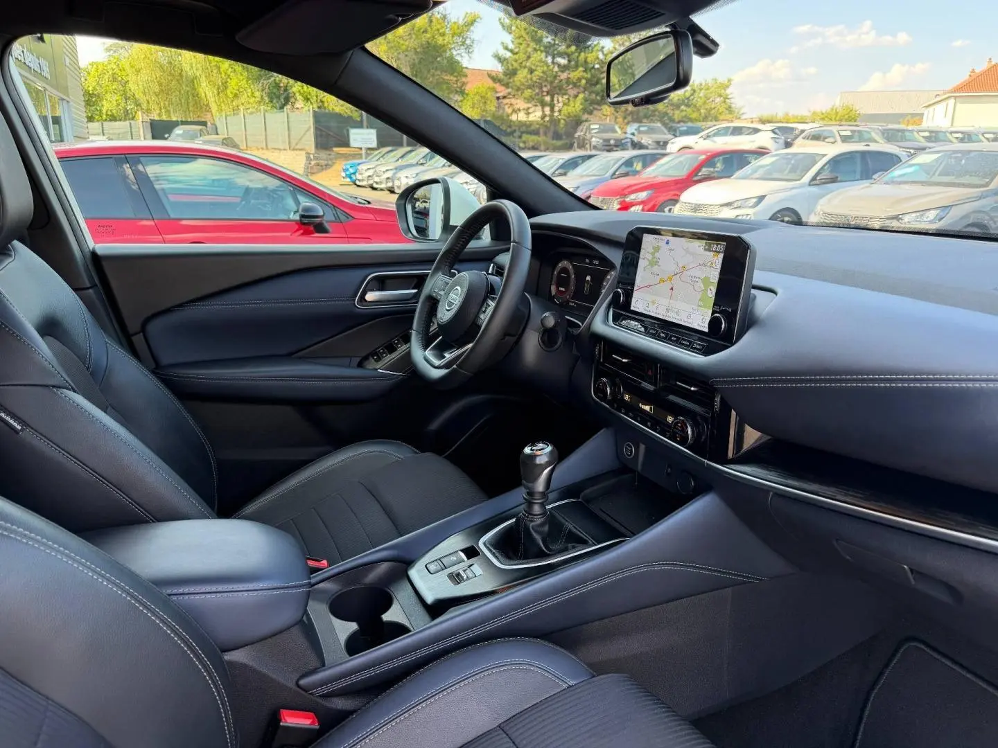 Vue intérieure côté conducteur du Nissan Qashqai 2022 Tekna, volant cuir, écran tactile et levier de vitesses manuel.