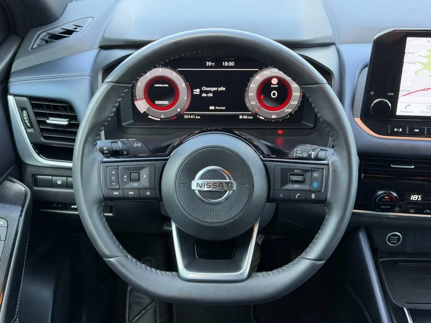 Vue centrée sur le volant cuir noir du Nissan Qashqai 2022 avec tableau de bord numérique et écran tactile latéral.