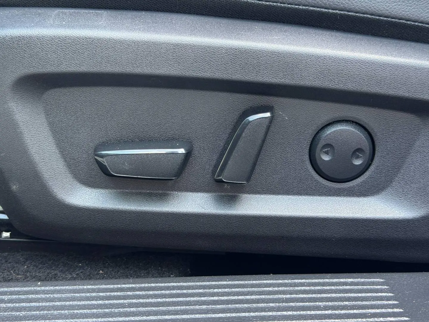 Gros plan sur les commandes électriques de réglage du siège conducteur du Nissan Qashqai Tekna 2022, finition noire.