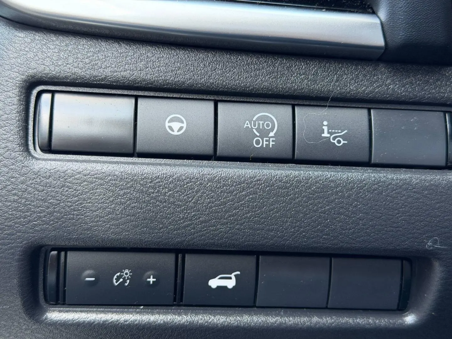 Gros plan sur les boutons de commande noirs du tableau de bord intérieur du Nissan Qashqai rouge 2022.