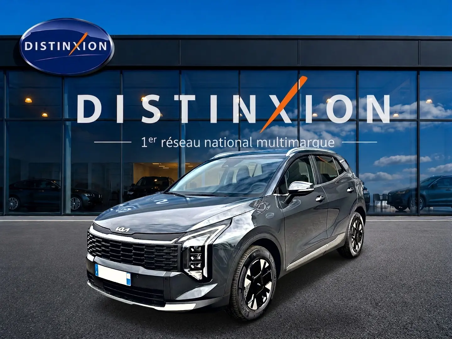 KIA Sportage 1.6 hybride gris eclipse en 3/4 avant droit, avec calandre noire et jantes alu noires et argentées.