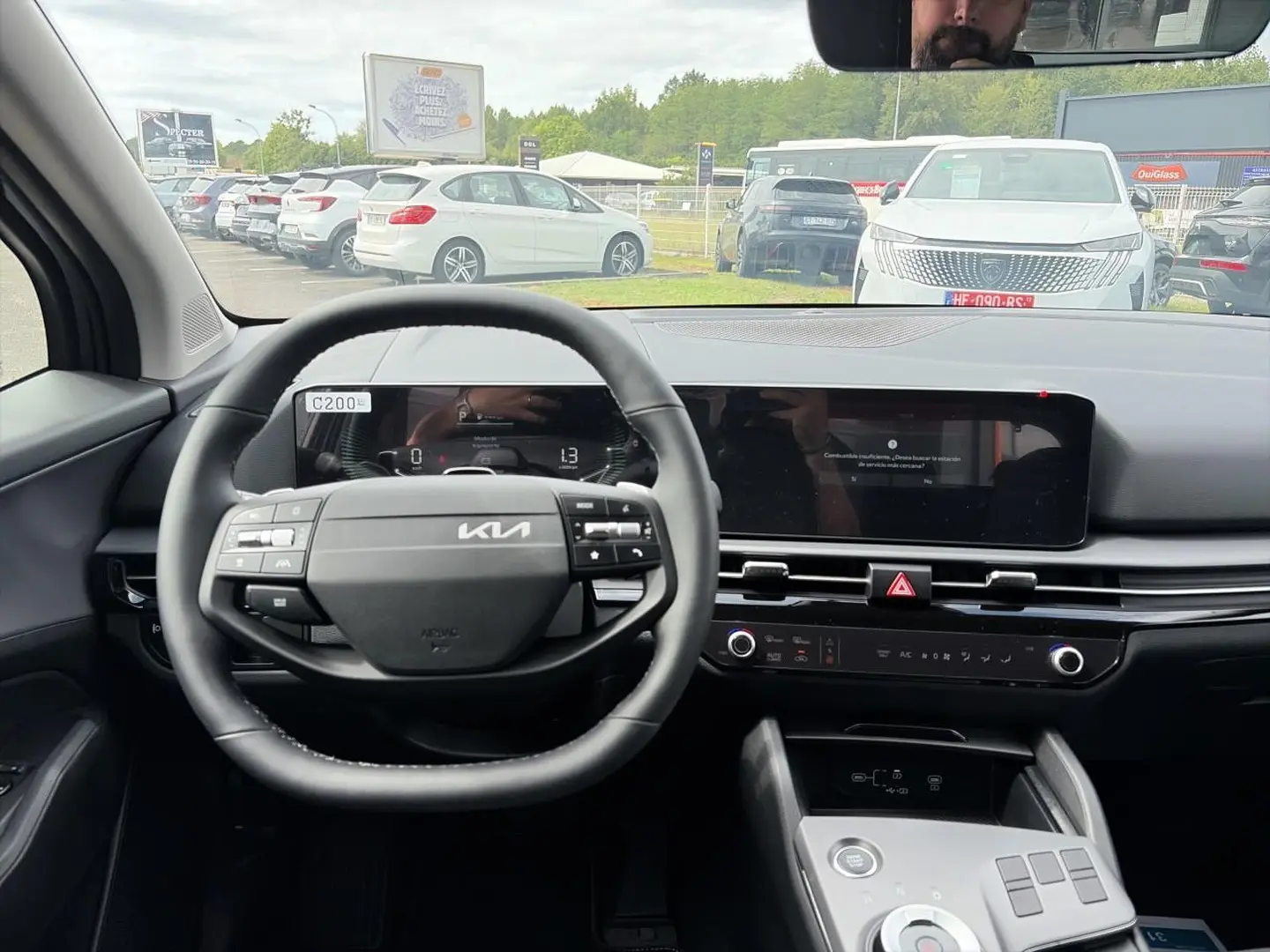 Vue intérieure centrée sur le volant cuir multifonction et l'écran tactile du Kia Sportage gris eclipse 2026.