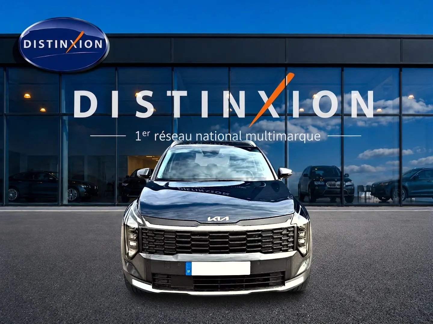 Vue frontale d'un KIA Sportage 1.6 hybride 239 gris eclipse avec calandre noire et phares LED distinctifs.
