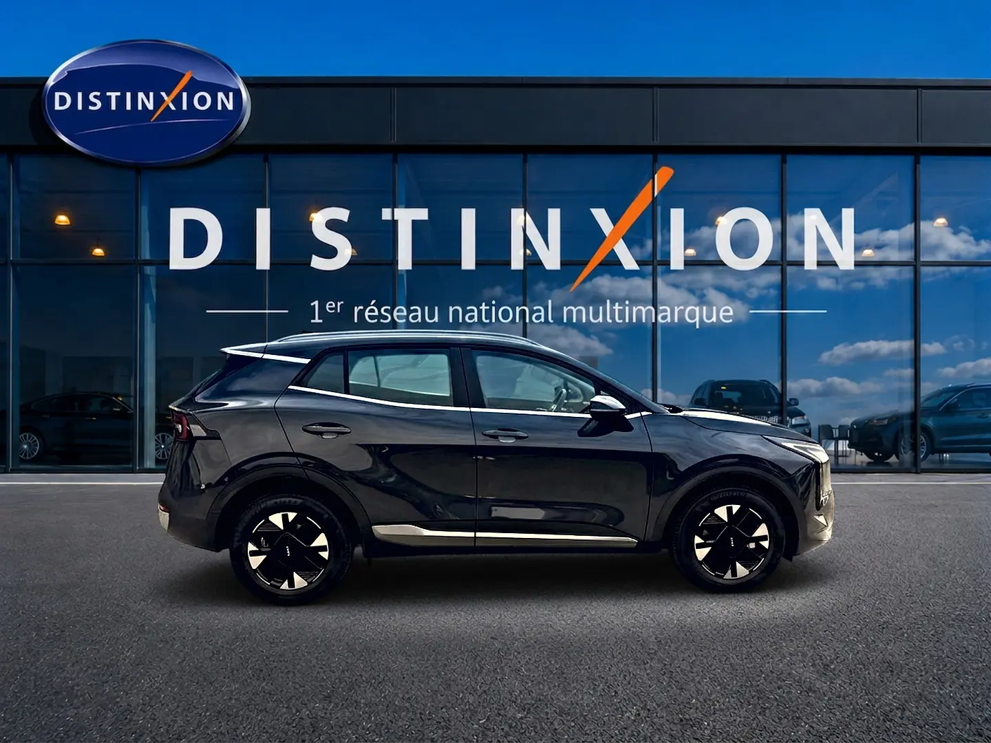 Profil côté gauche du KIA Sportage 1.6 hybride 239 gris eclipse, avec jantes alu et barres de toit visibles.