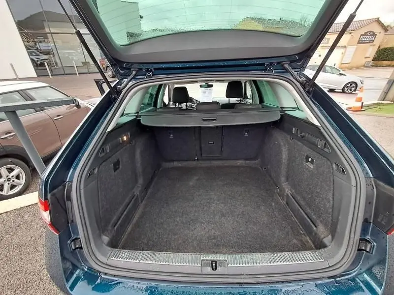 Coffre ouvert vu de l'arrière d'une Skoda Superb Combi bleu métal 2018, montrant un espace de chargement spacieux et propre.