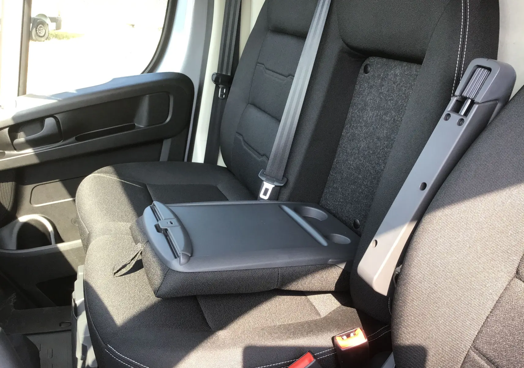 Vue intérieure côté droit du siège passager noir avec accoudoir et ceinture de sécurité du Peugeot Boxer Fourgon 2025.