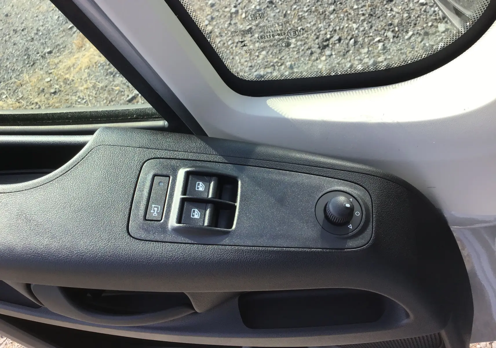 Gros plan sur la commande des vitres et rétroviseurs côté conducteur du Peugeot Boxer Fourgon gris Artense 2025.