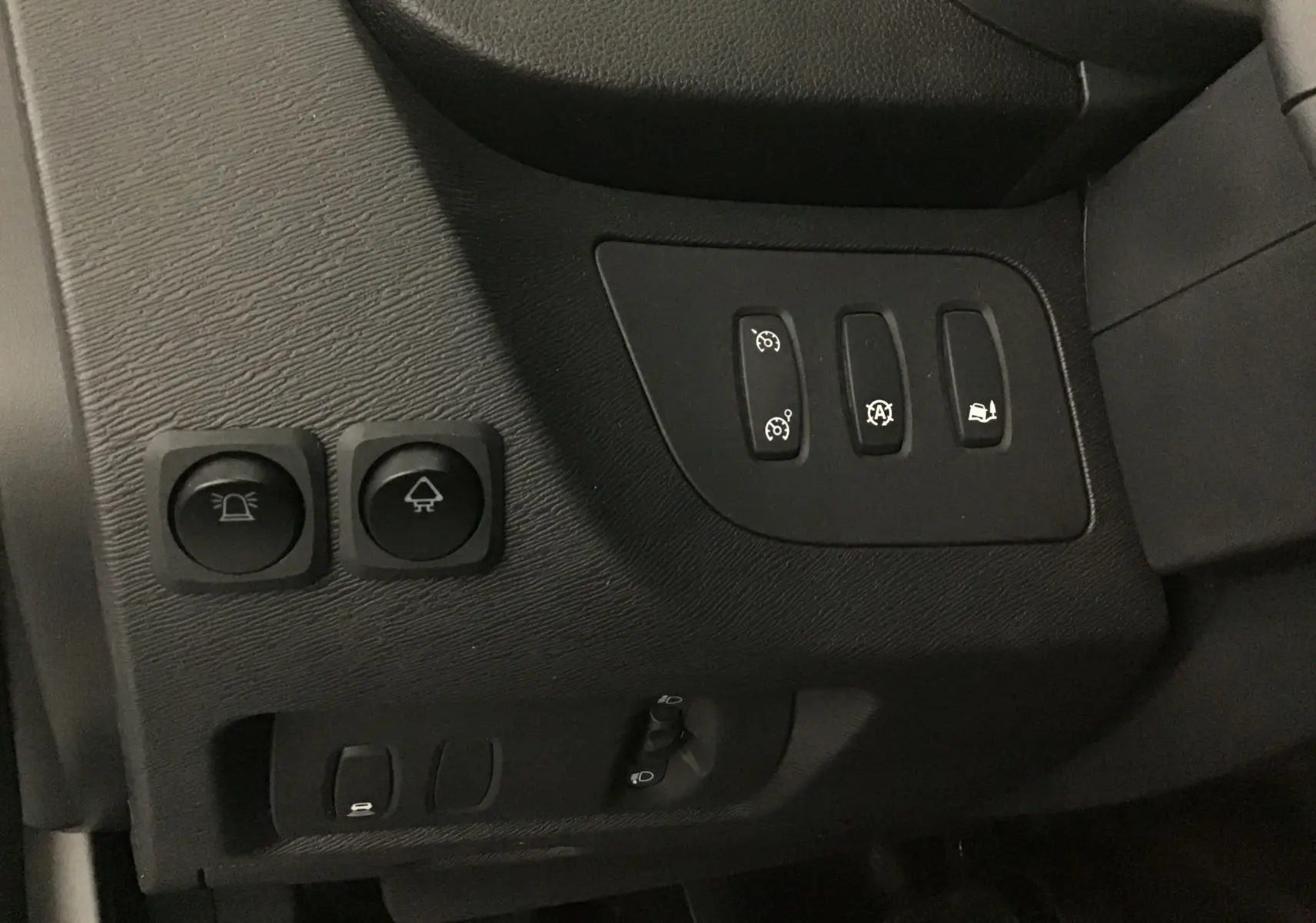 Gros plan sur les commandes noires du tableau de bord côté gauche du Renault Kangoo blanc 2021 diesel.