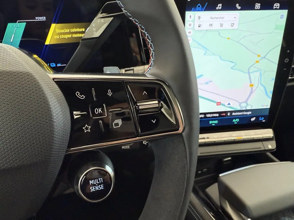 Gros plan sur le volant cuir et suede avec commandes multifonctions, et écran tactile de navigation du Renault Espace gris foncé esprit Alpine.