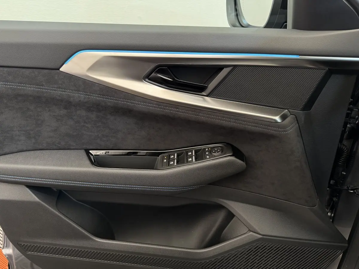Détail de la porte côté conducteur du Renault Espace Esprit Alpine 2025, garniture noire avec surpiqûres bleues et inserts métalliques.