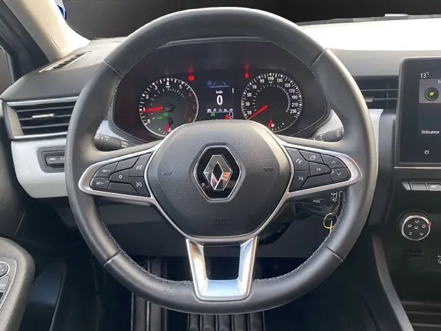 Vue intérieure centrée sur le volant TEP noir de la Renault Clio V TCE 90 Evolution avec tableau de bord et écran multimédia.