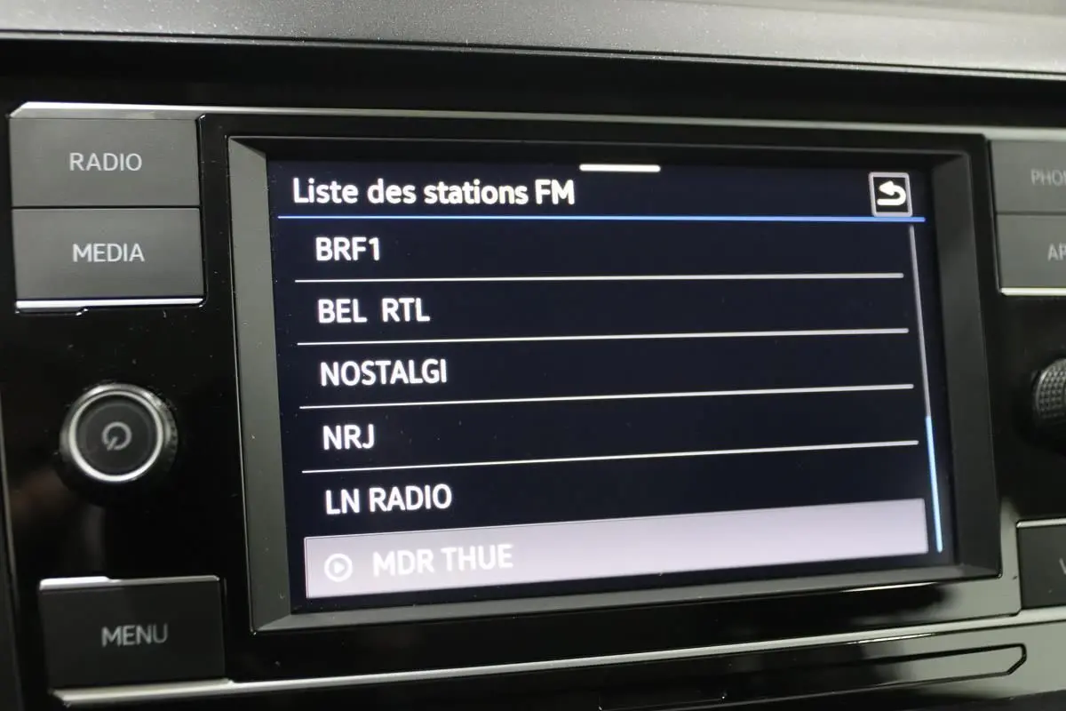 Écran tactile central affichant la liste des stations FM dans une Volkswagen Polo 2022, intérieur noir.