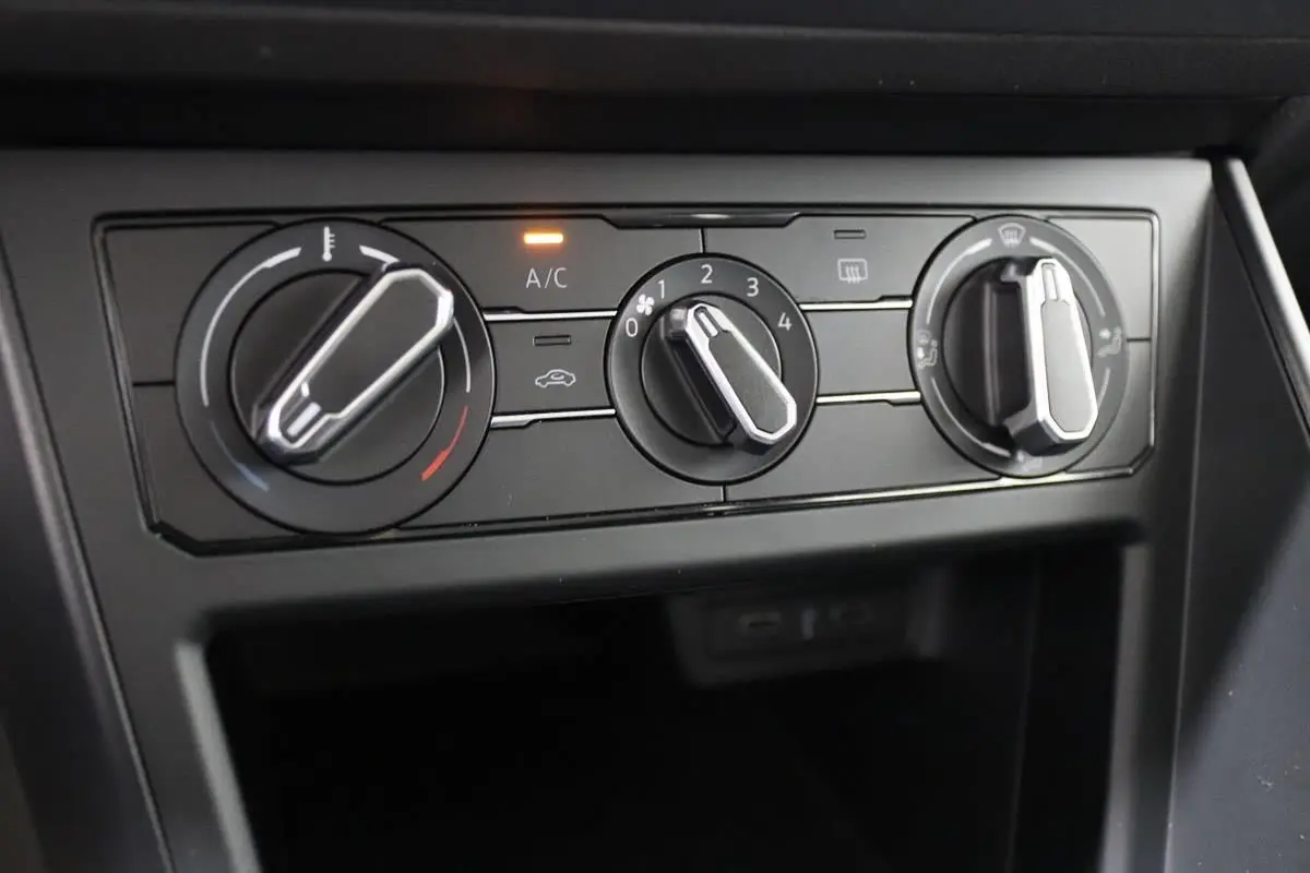Gros plan sur les commandes de climatisation manuelle du Volkswagen Polo 1.0 blanc, avec témoin A/C allumé.