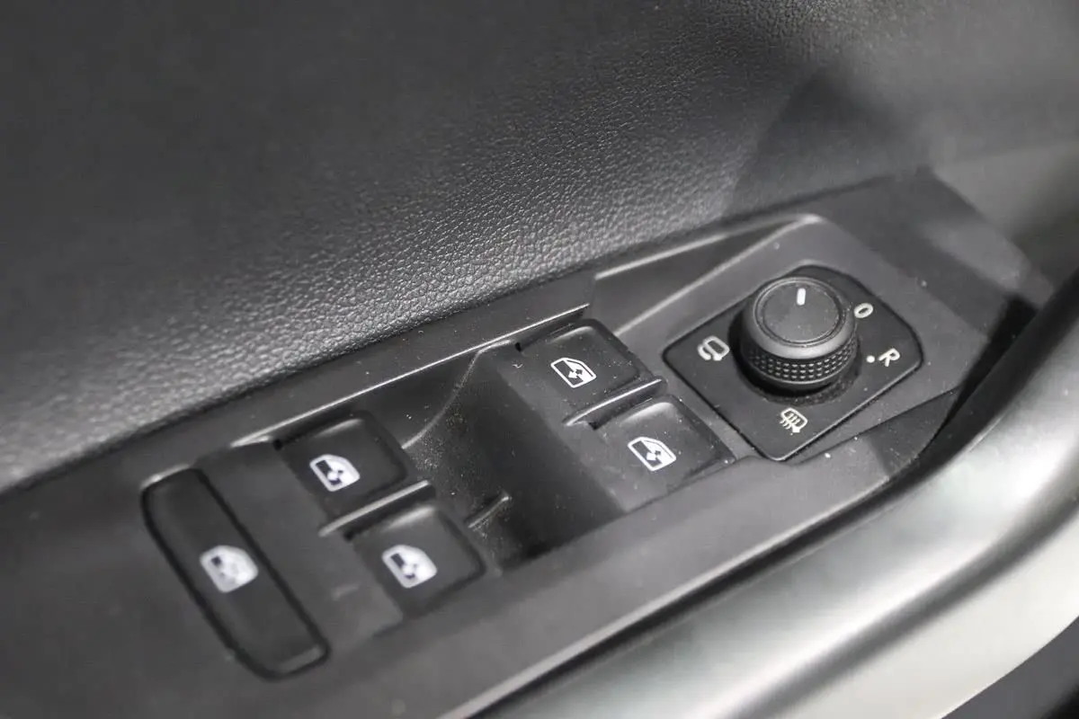 Commande des vitres électriques et réglage des rétroviseurs sur la porte côté conducteur d'une Volkswagen Polo blanche 2022.