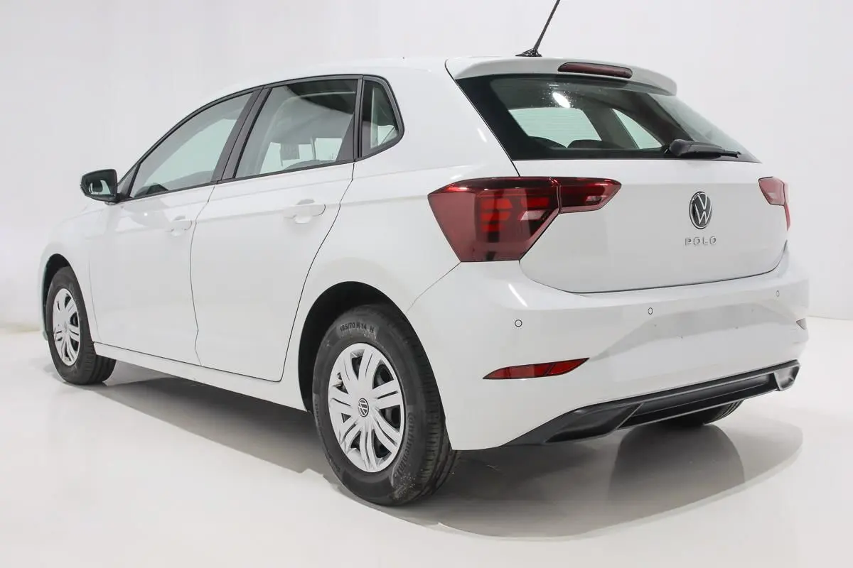 Vue 3/4 arrière droite d'une Volkswagen Polo blanche 5 portes avec feux arrière LED et radar de recul visible.