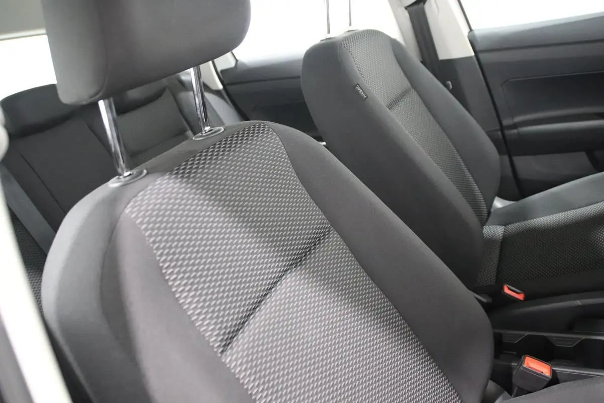 Gros plan sur les sièges avant en tissu gris de la Volkswagen Polo 1.0 80 BVM, intérieur sobre et fonctionnel.