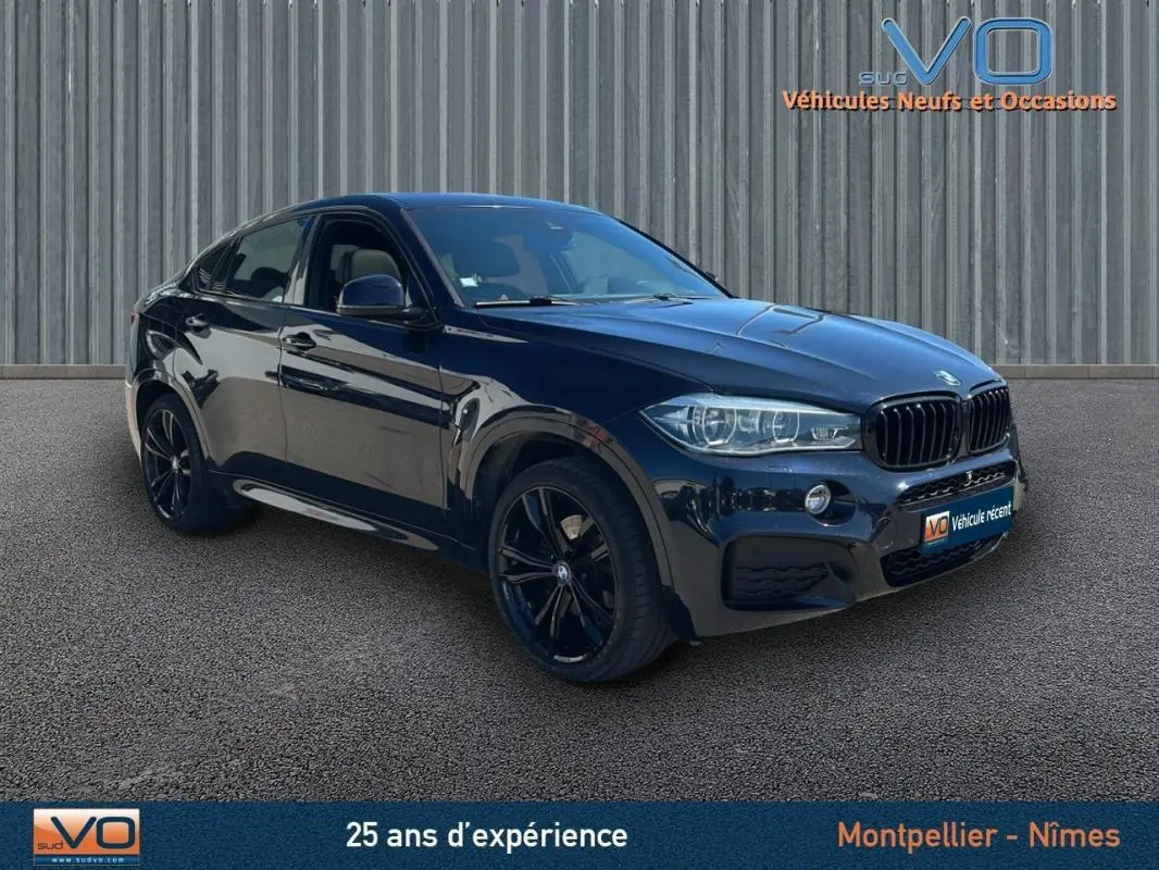 BMW X6 F16 xDrive40d noir en 3/4 avant droit, avec jantes alliage noires et calandre sportive M Sport.