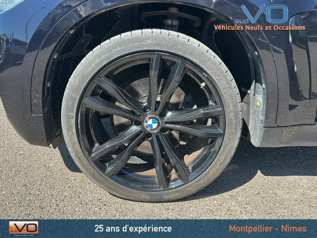 Gros plan sur la jante alliage noire 19 pouces du BMW X6 F16 noir, mettant en valeur le logo BMW central.