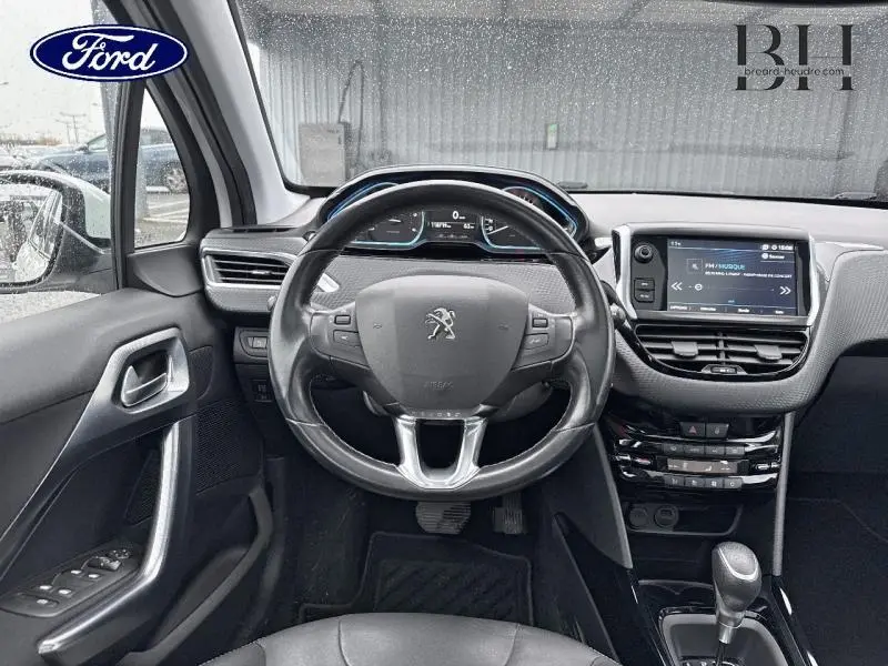 Vue intérieure centrée sur le volant cuir multifonction et tableau de bord numérique du Peugeot 2008 blanc Banquise 2019.