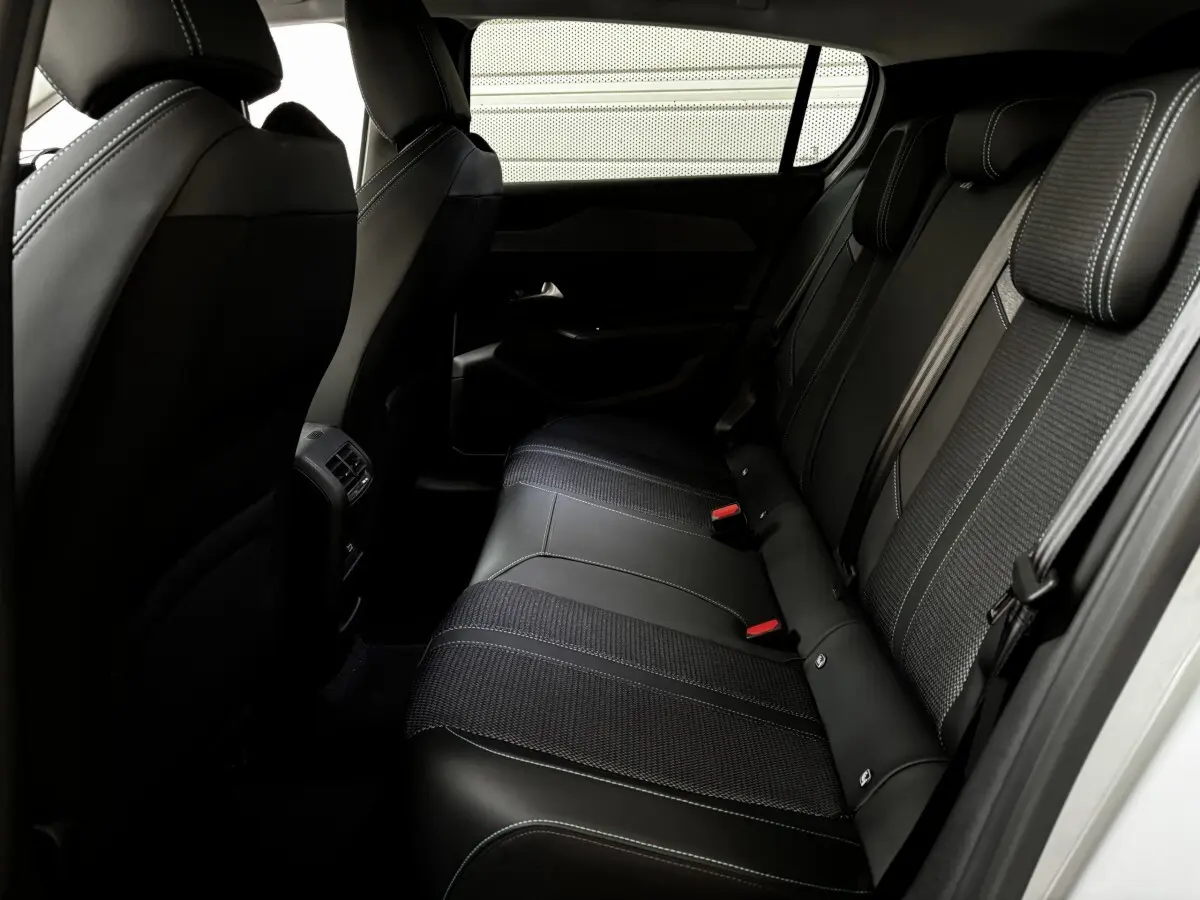 Vue intérieure côté droit des sièges arrière noirs en cuir et tissu de la Peugeot 308 Hybrid 145 e-DCS6 Allure 2025.